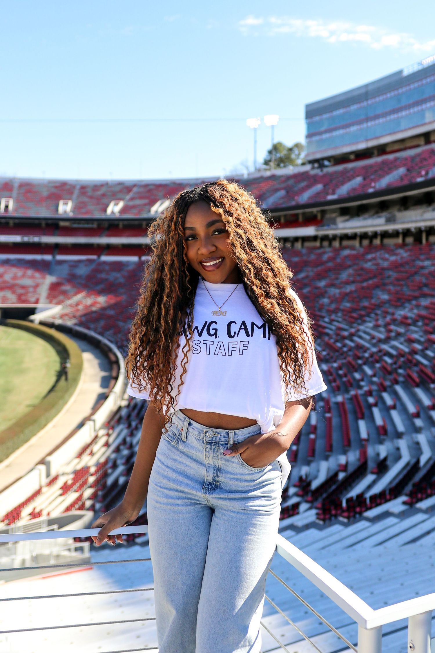 A series of photos taken at a large football stadium showing someone posing on the bleachers in casual attire.