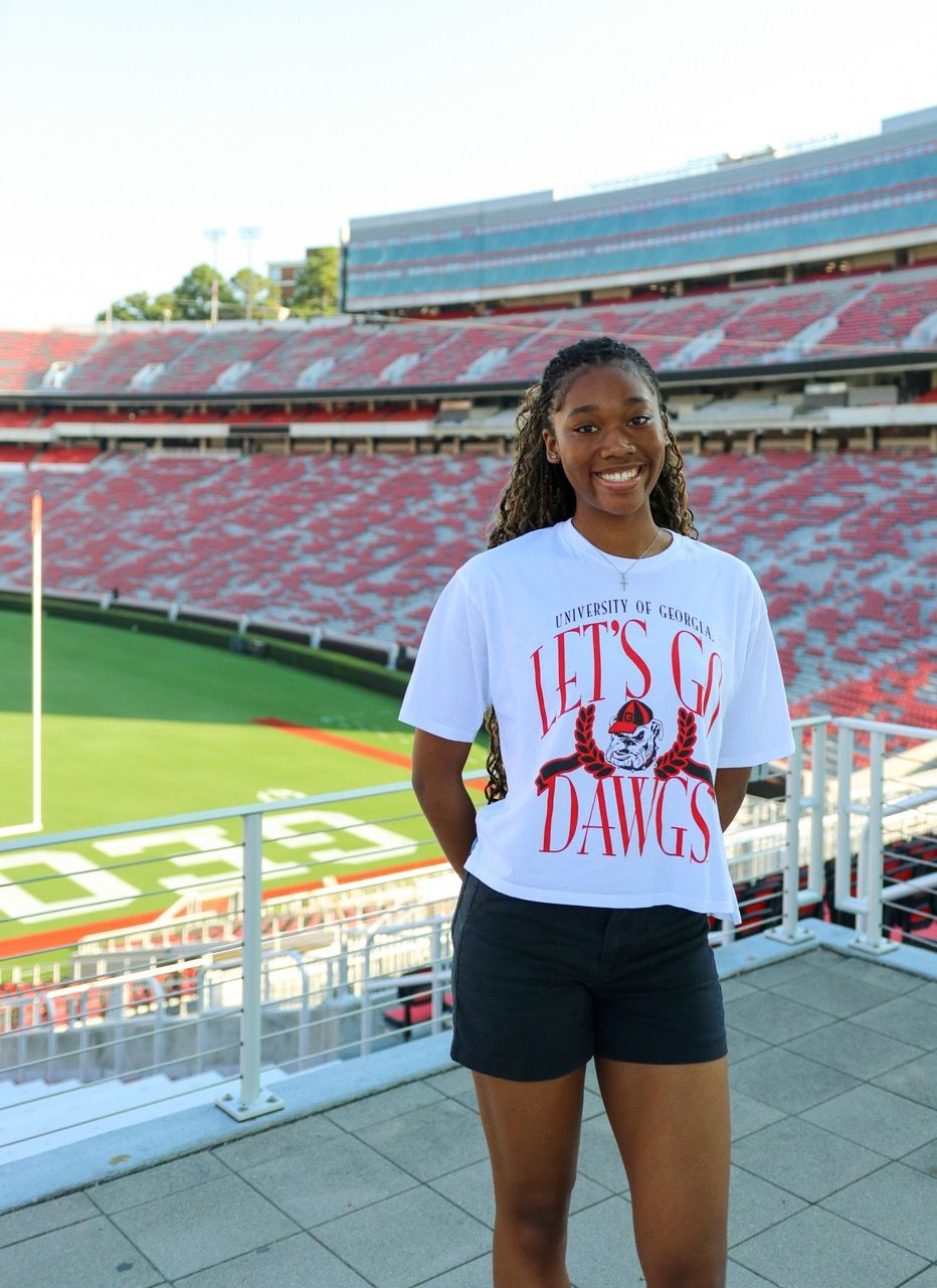 A series of photos at a football stadium showing someone posing in a red and white Georgia Bulldogs fan t-shirt and shorts.