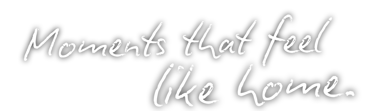 Faded gray text reading 'Moments that feel like home' appears in a handwritten style against a white background.