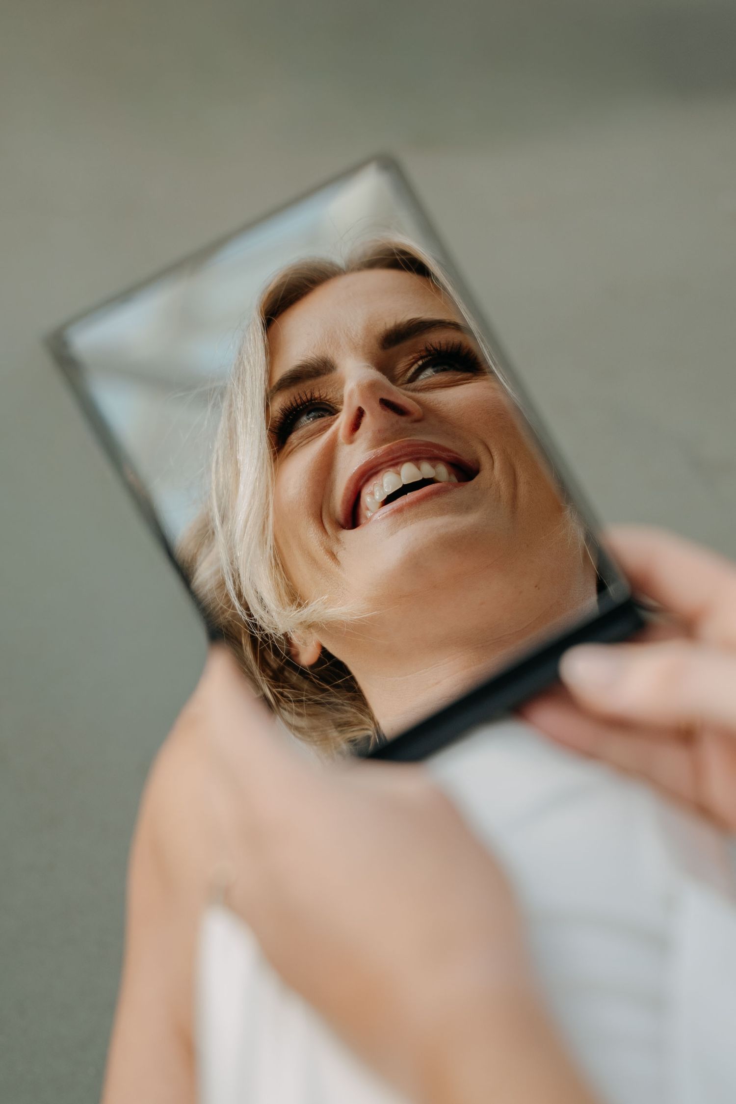 A sequence of five close-up shots showing a joyful expression and laughter against a light background.