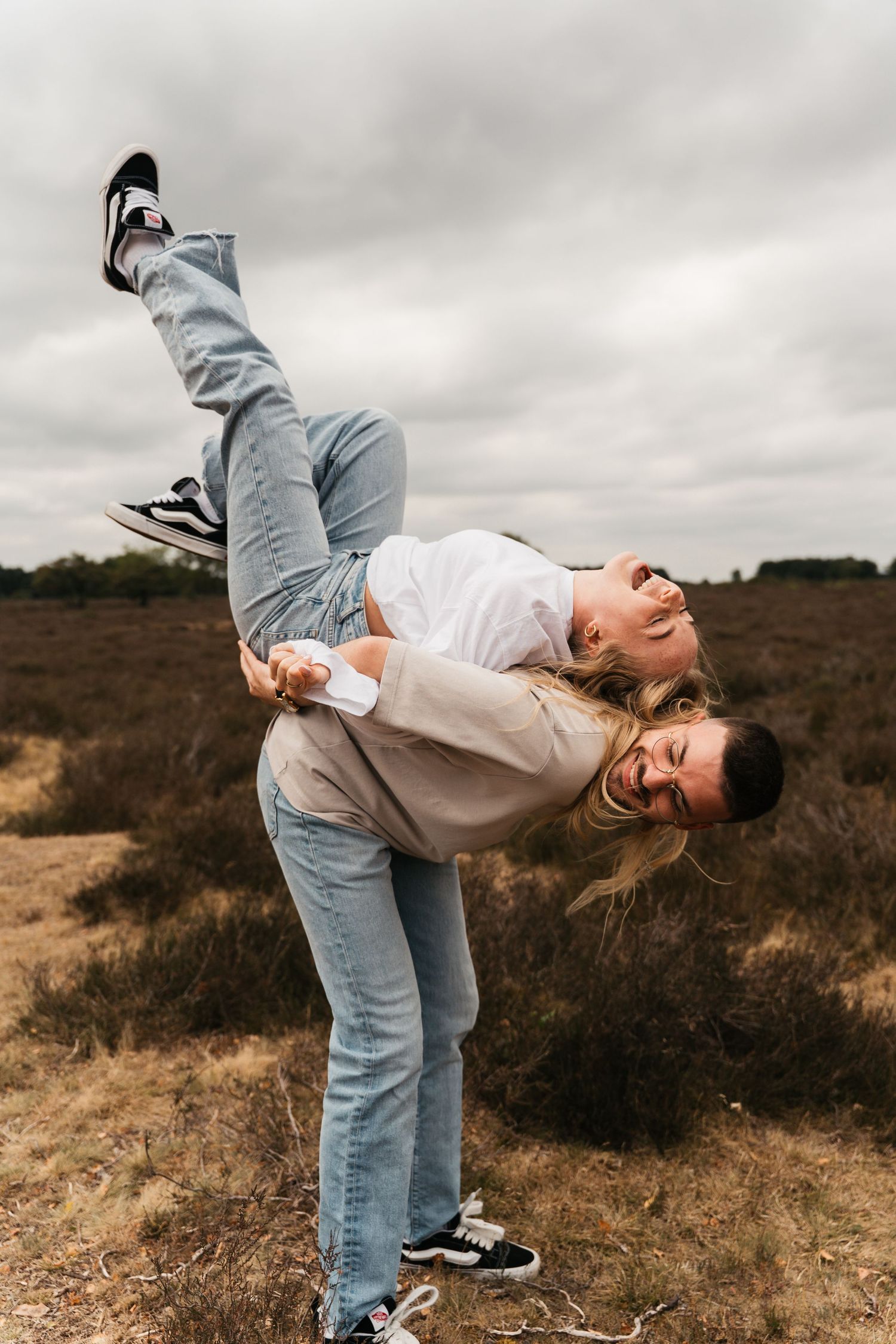Een verliefd stel op de paarse heide in Laren tijdens een frisse lentedag.