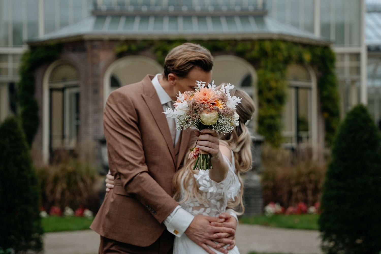 Elegant outdoor garden wedding ceremony setup with floral decorations and greenery.