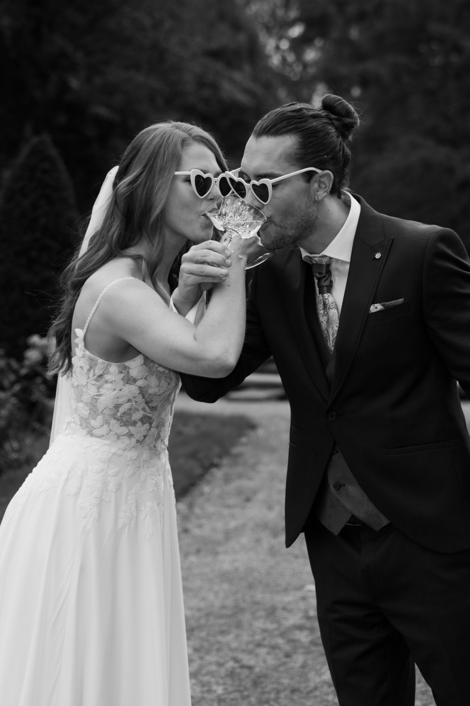 Playful wedding moment with sunglasses in black and white photography.
