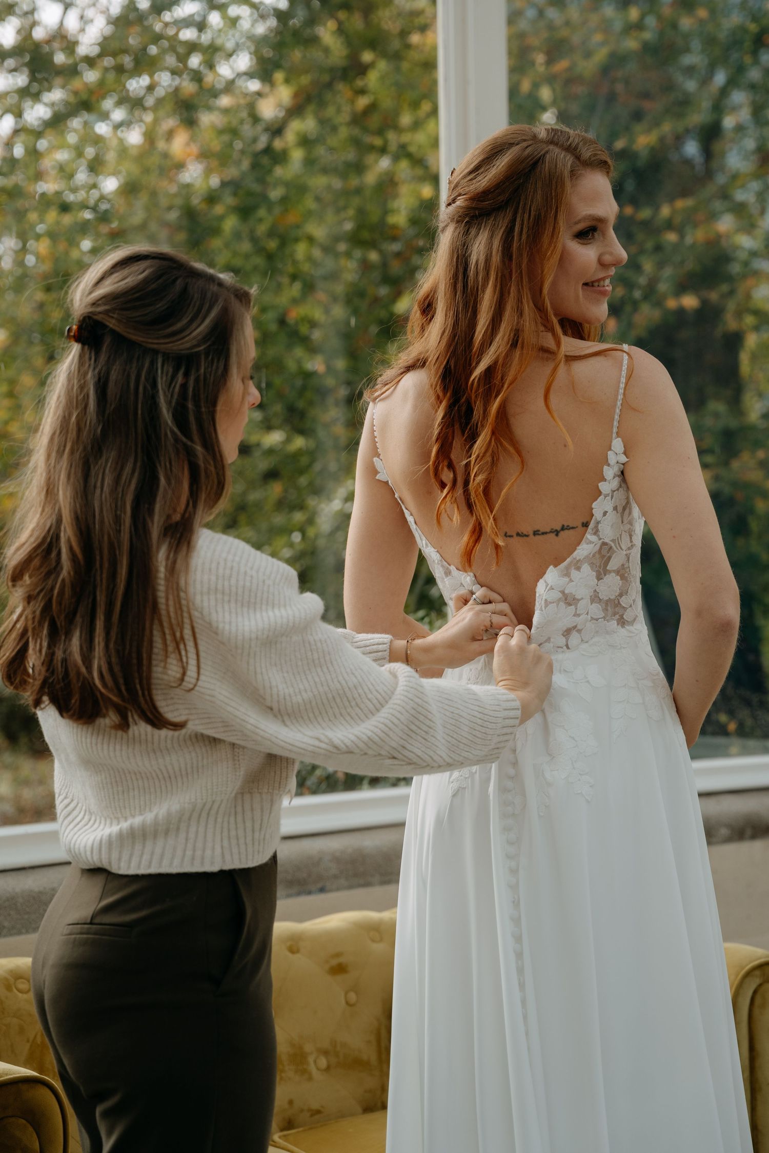 Wedding dress preparation scene with intricate lace details and buttons.