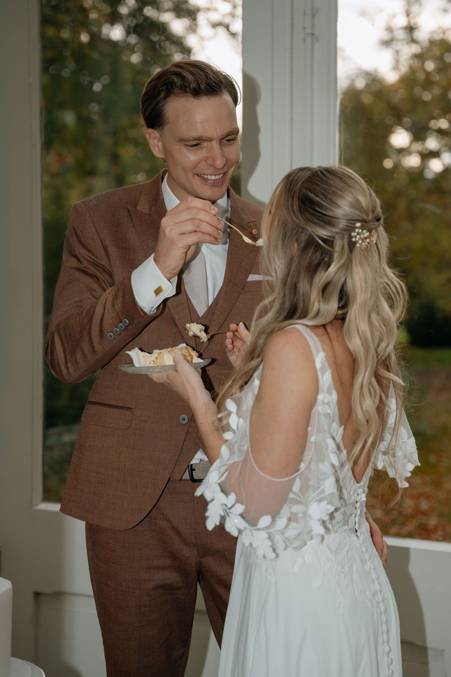 Newlywed couple shares wedding cake during intimate moment on their special day.