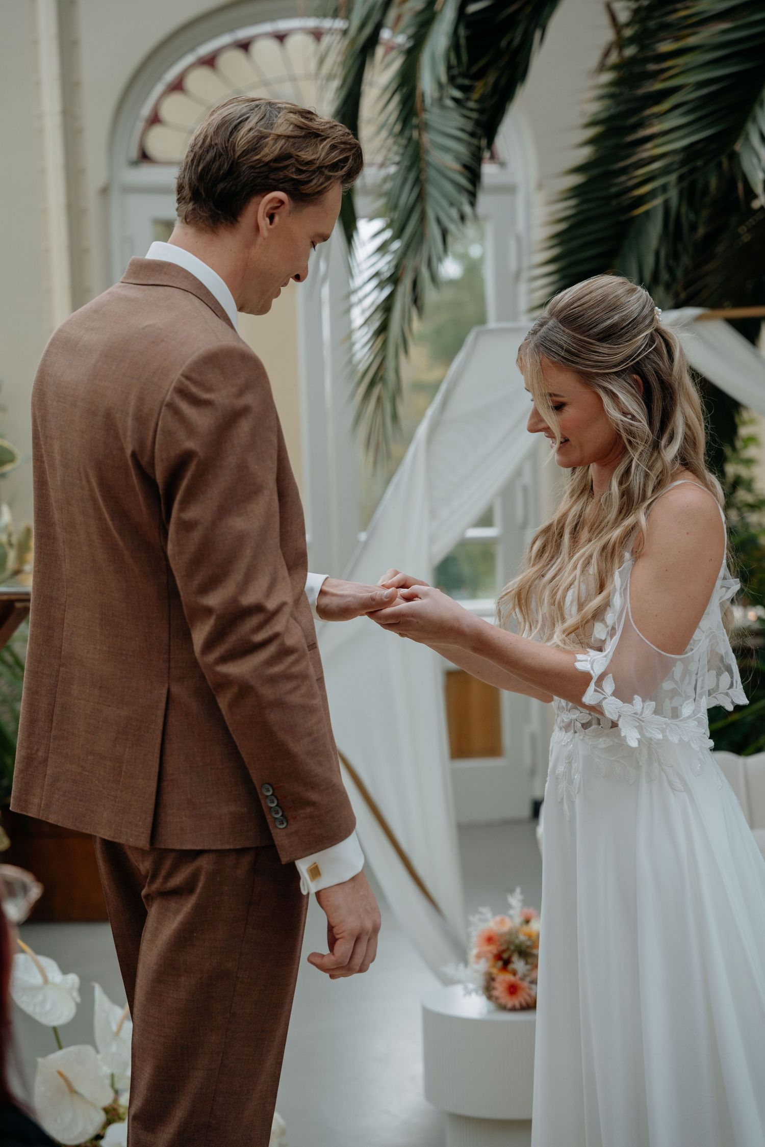 A wedding first look moment captured in a series of photos showing a bride in white and groom in brown suit.