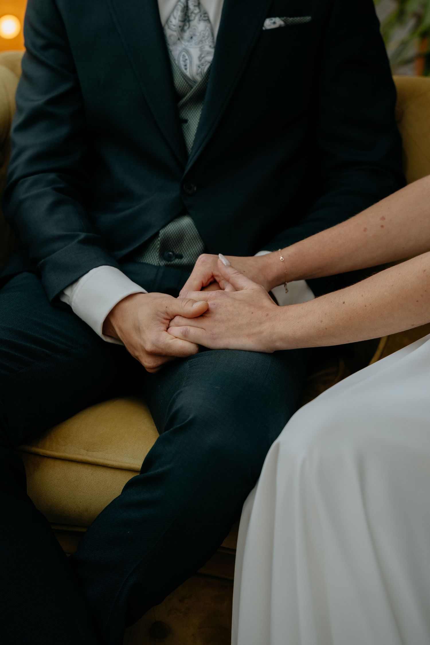 Close-up shot of a couple holding hands during their wedding ceremony.