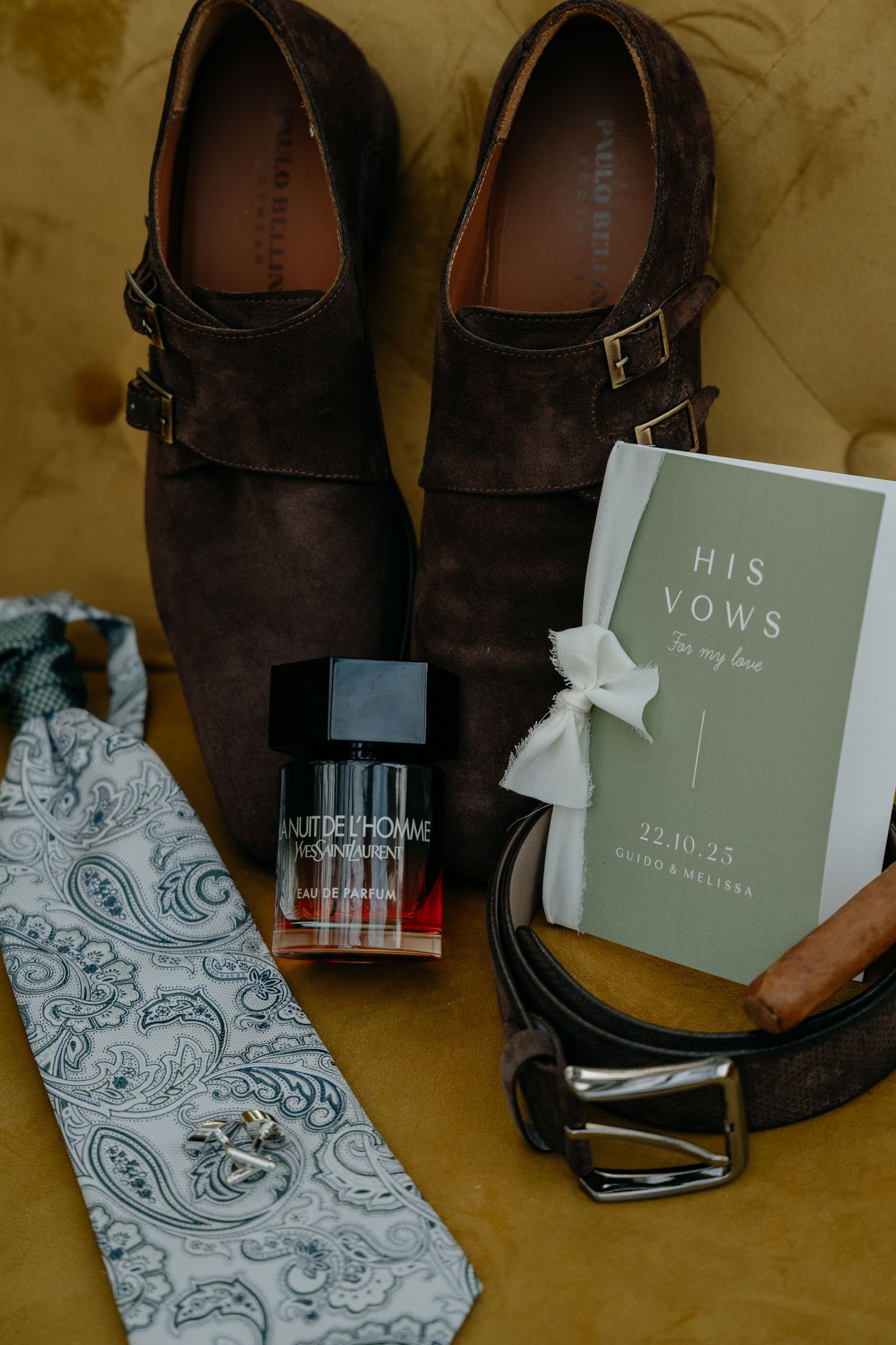 Wedding details showing dress shoes and vow books with delicate floral patterns.