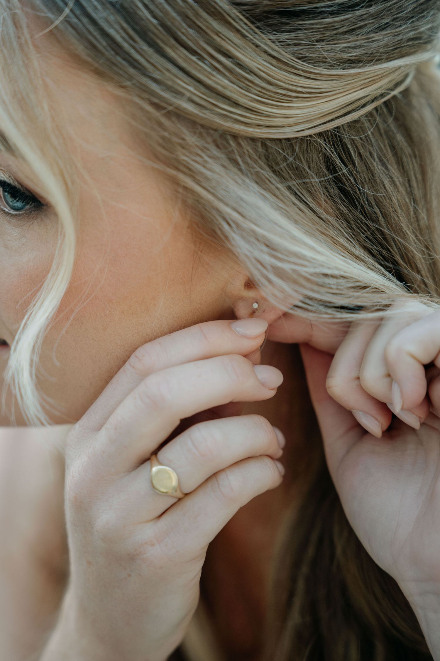 A person with blonde hair holds their hand to their face in a series of close-up emotional poses.