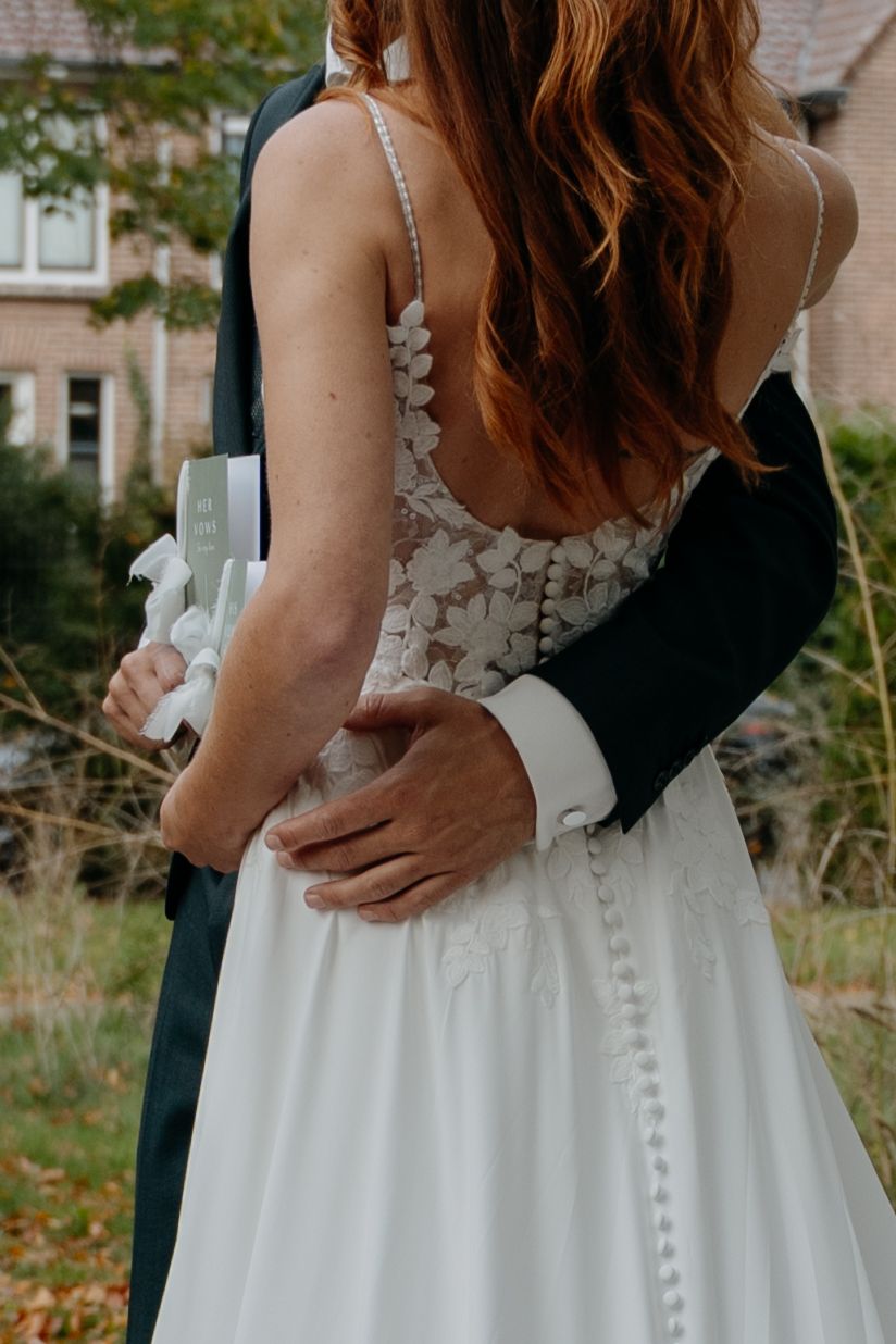 Close-up of wedding dress details showing intricate button closures and lace.