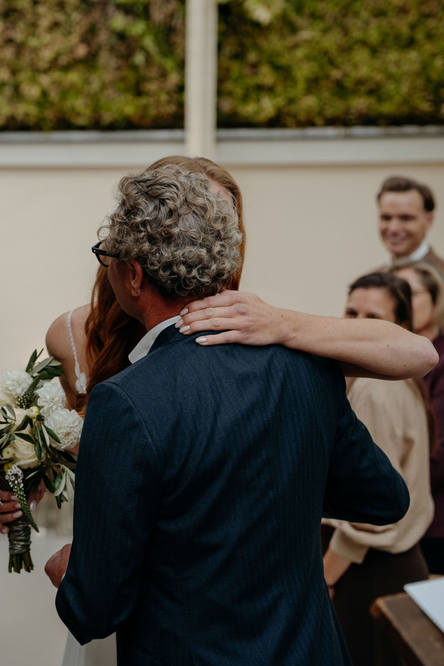 Wedding ceremony guests embracing and celebrating during an emotional moment.
