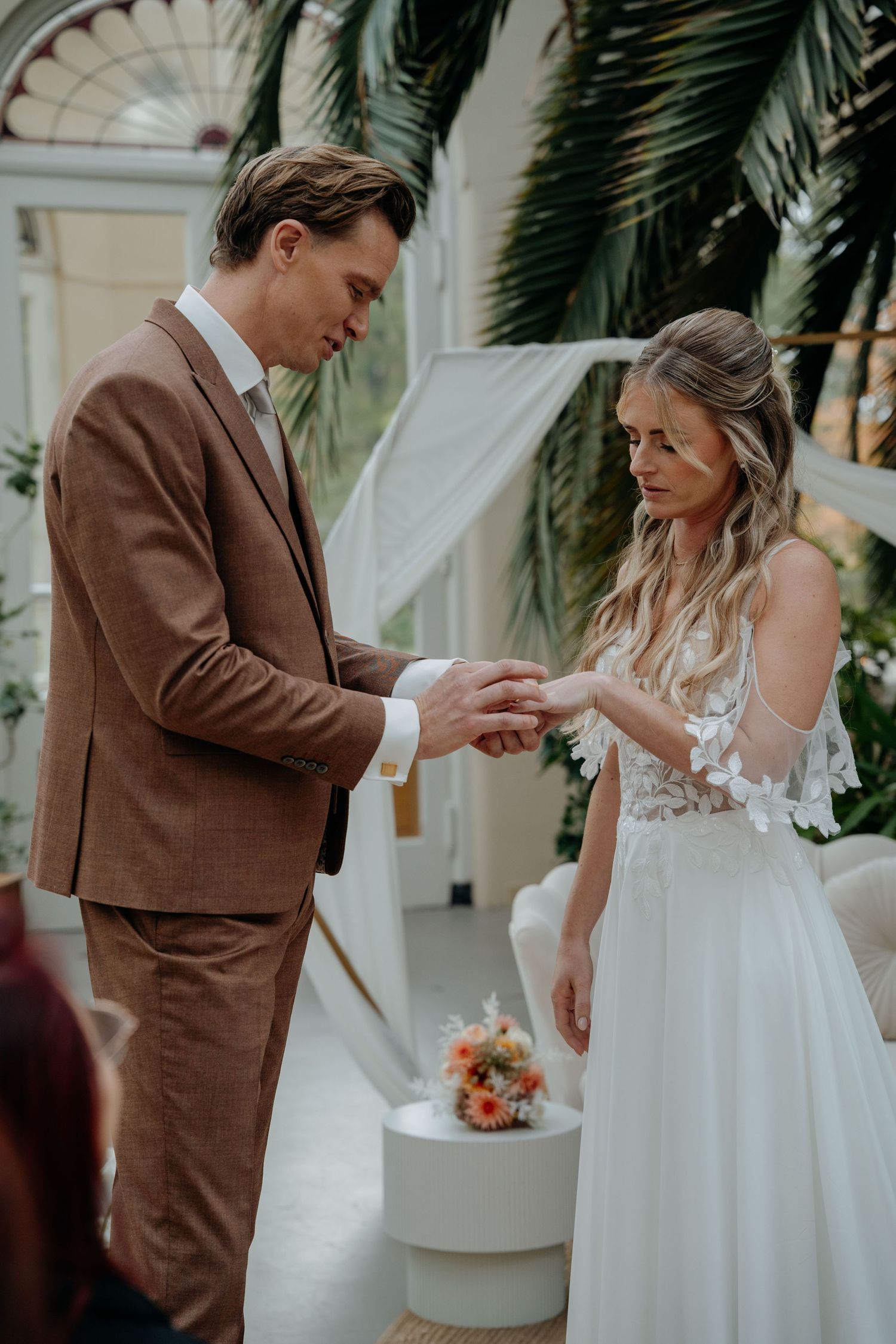 A couple shares a tender moment during their wedding cake cutting ceremony in a romantic outdoor setting.