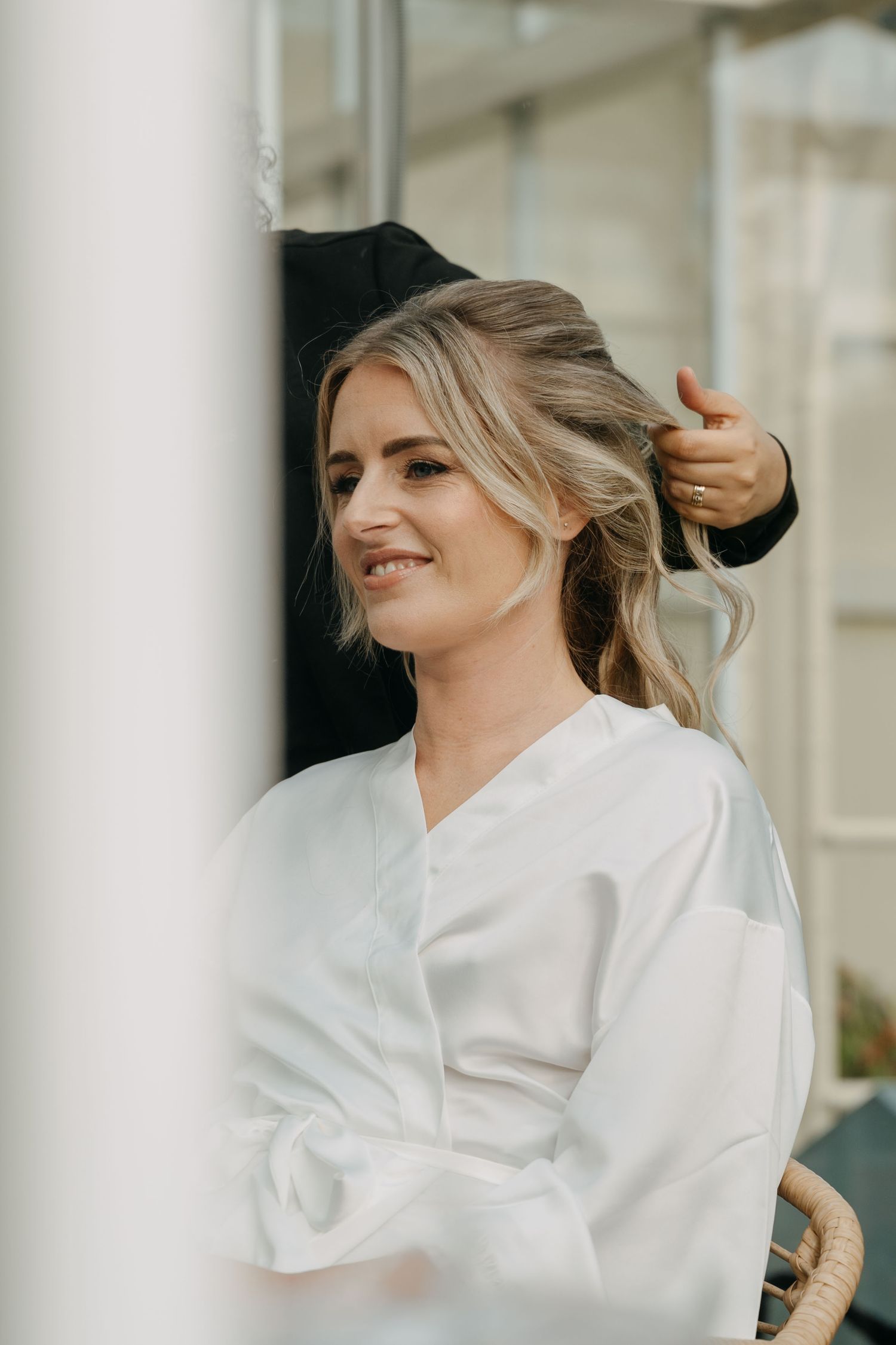 A series of photos showing someone wearing a white silk robe while getting ready in an elegant setting.