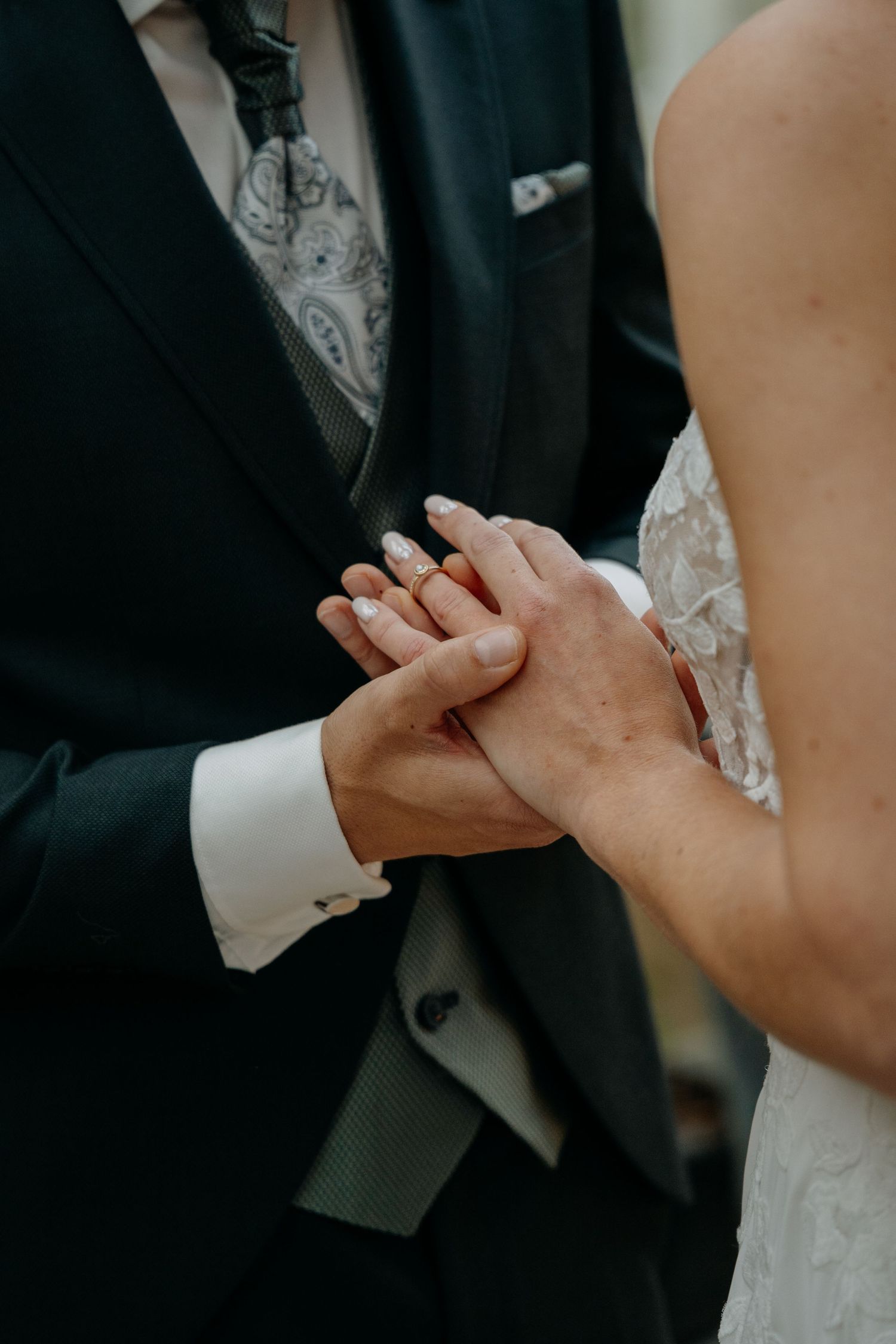 Close-up shots of hands clasping together during an intimate wedding moment.