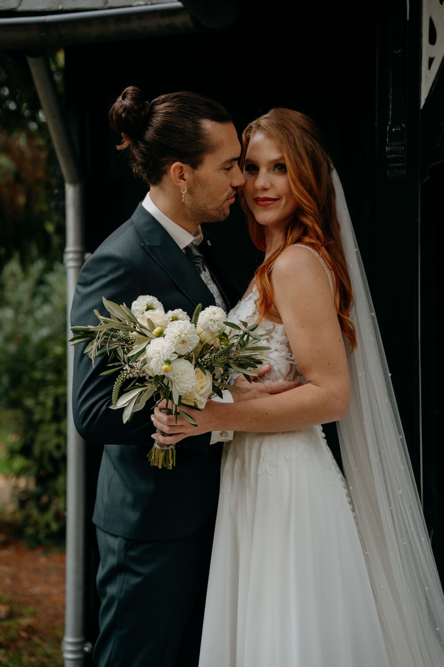 A romantic wedding moment captured with white flowers and elegant attire.