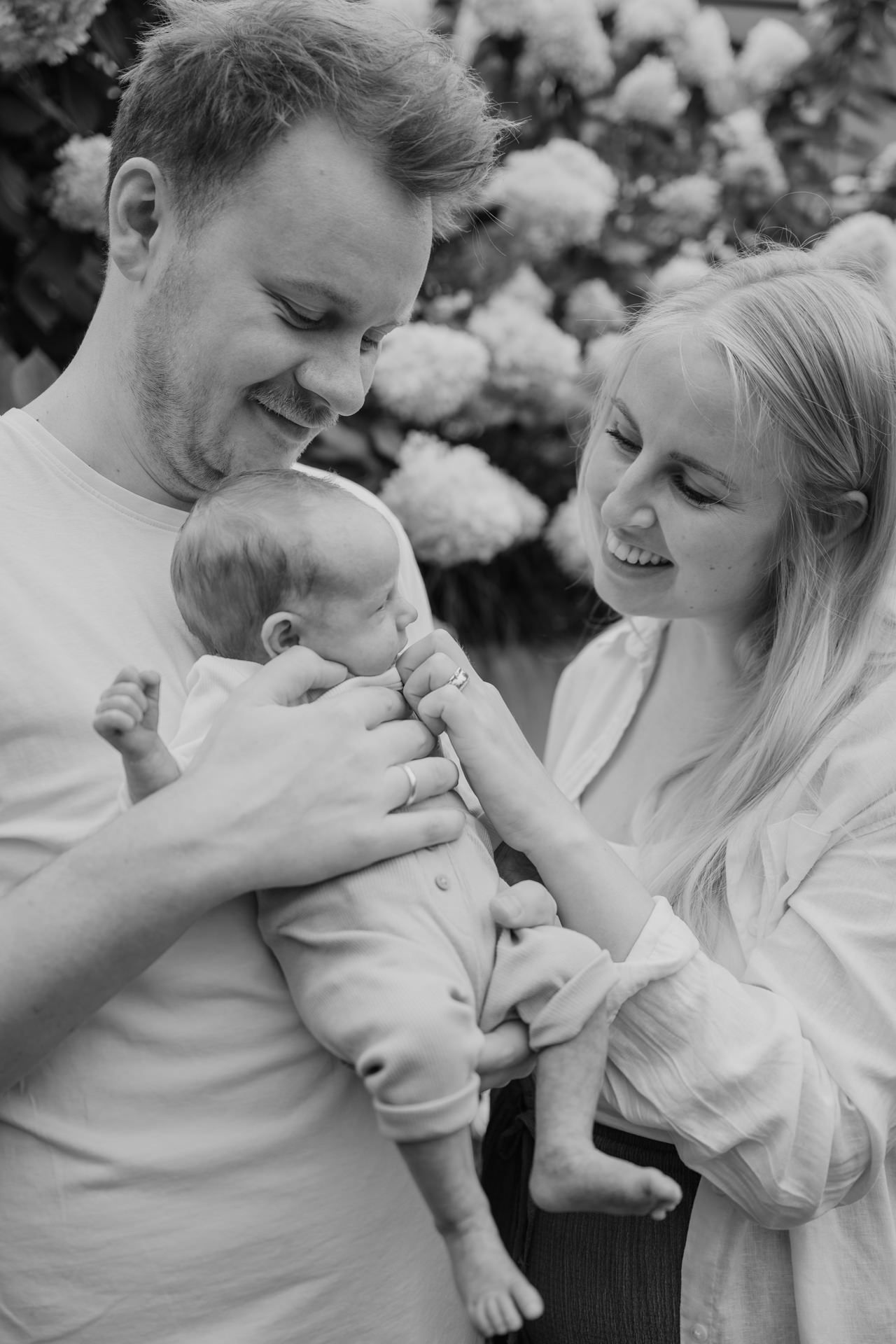 Familienportrait mit Mama, Papa und Neugeborenen in schwarzweiss