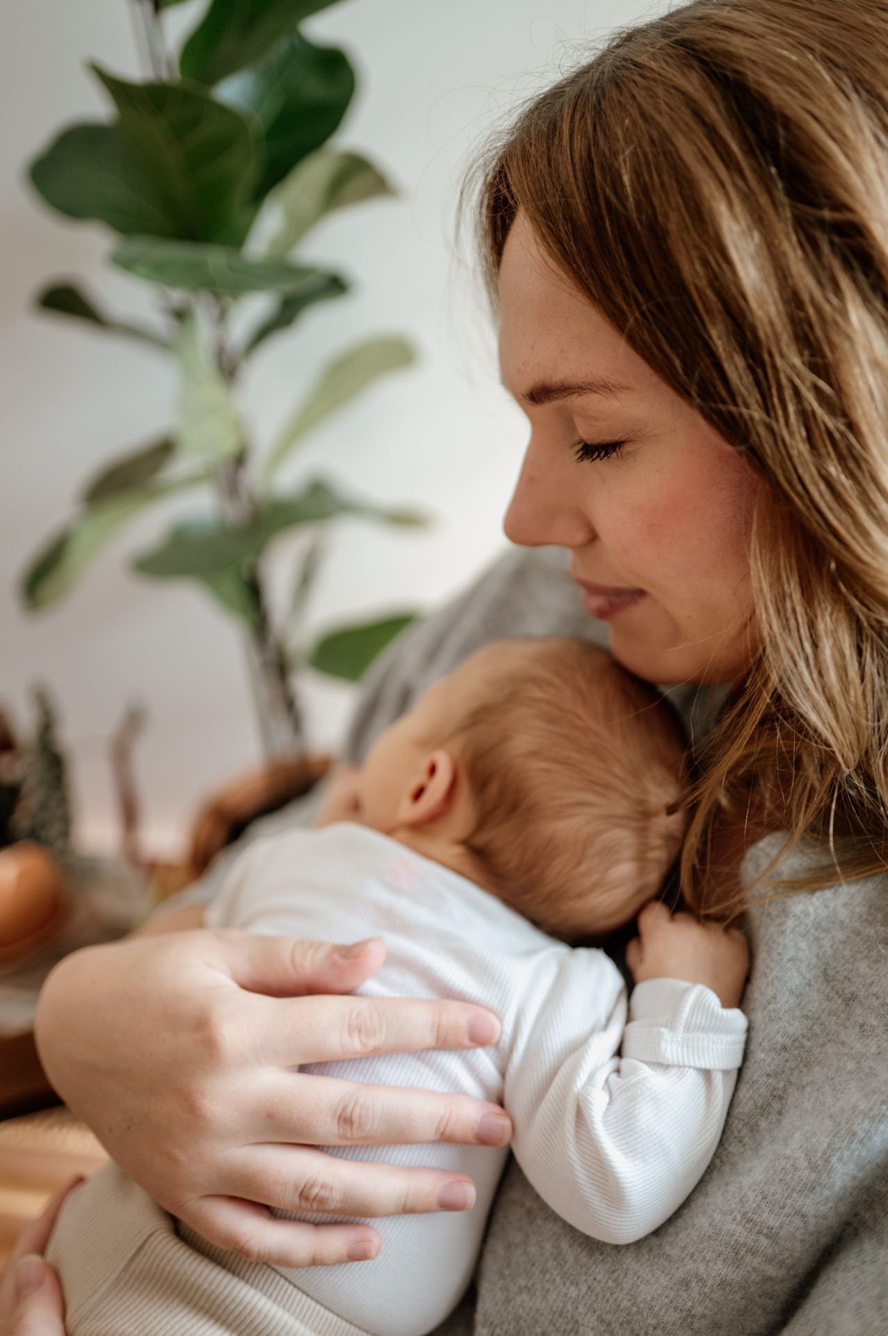Baby liegt an Mamas Brust gelehnt