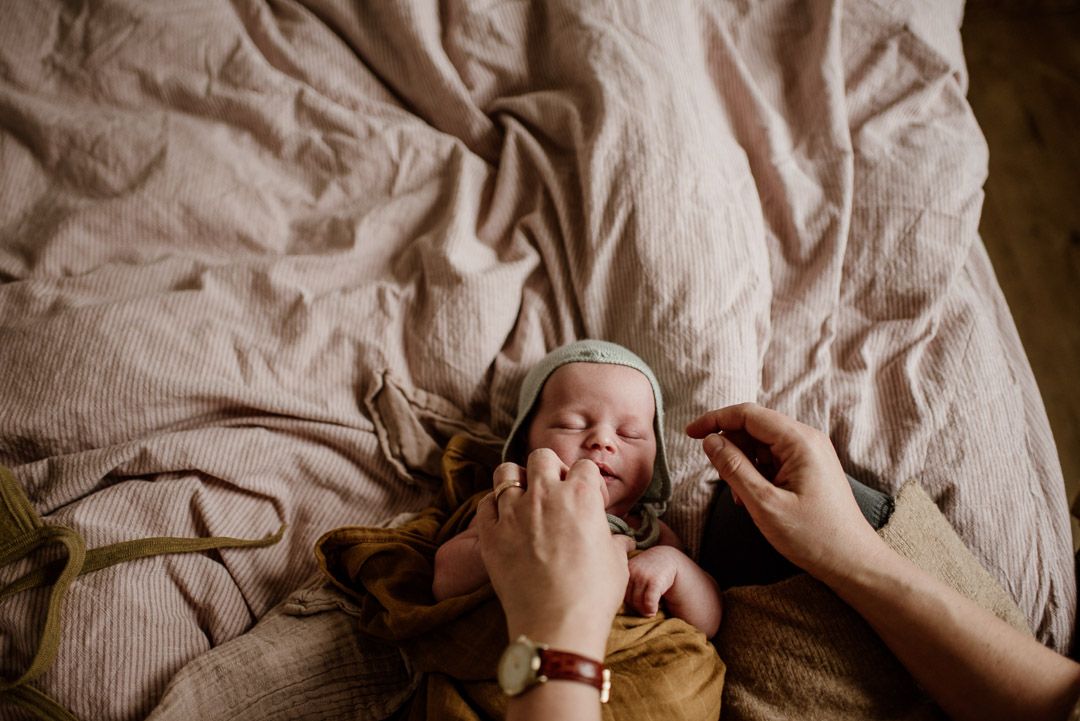 Baby auf Bett wird angezogen