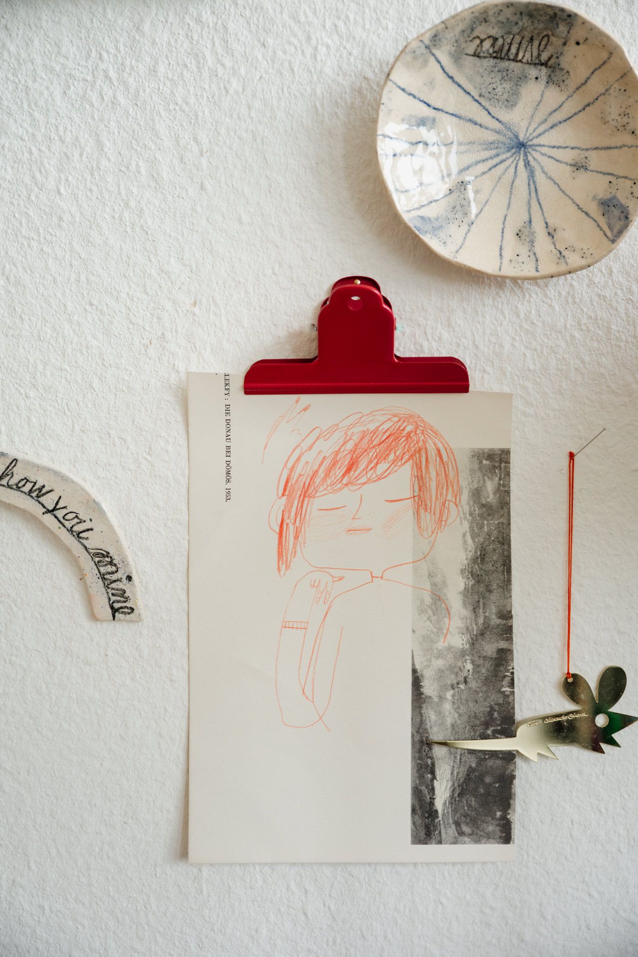 kleine Kunstwerke hängen an einer Wand