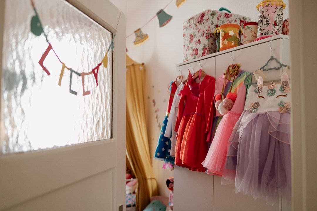 Einblick in ein Mädchenkinderzimmer mit vielen bunten Kostümen