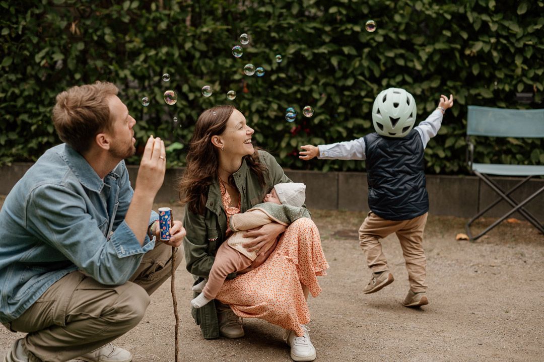 eine Familie mit Kindern spielt Seifenblasen