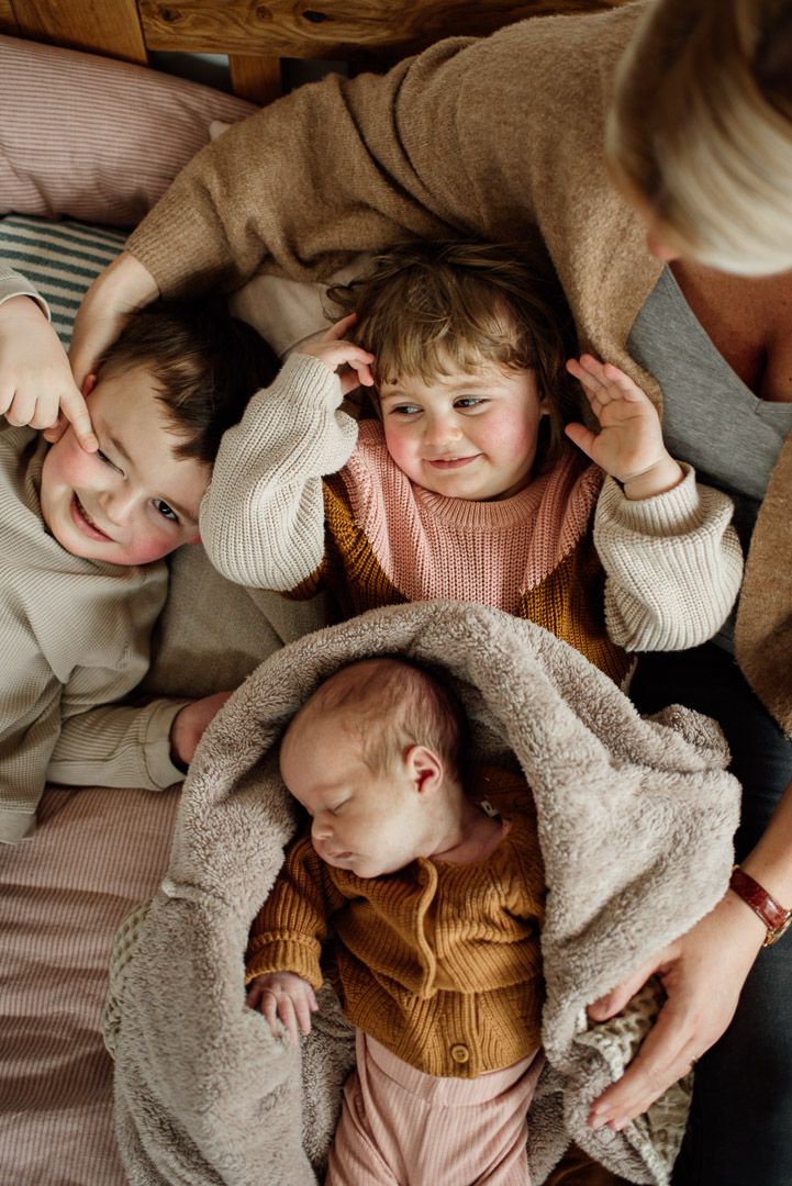 drei Kinder werden in den Armen ihrer Mutter gehalten