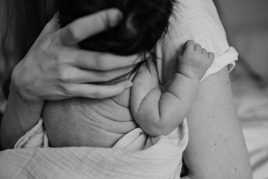 behaarter Babyrücken im Arm seiner Mama
