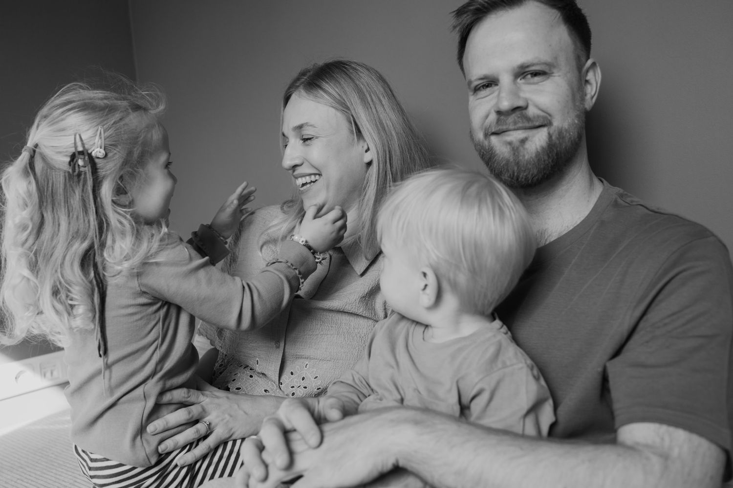 natürliches Portrait einer Familie beim kuscheln und spielen