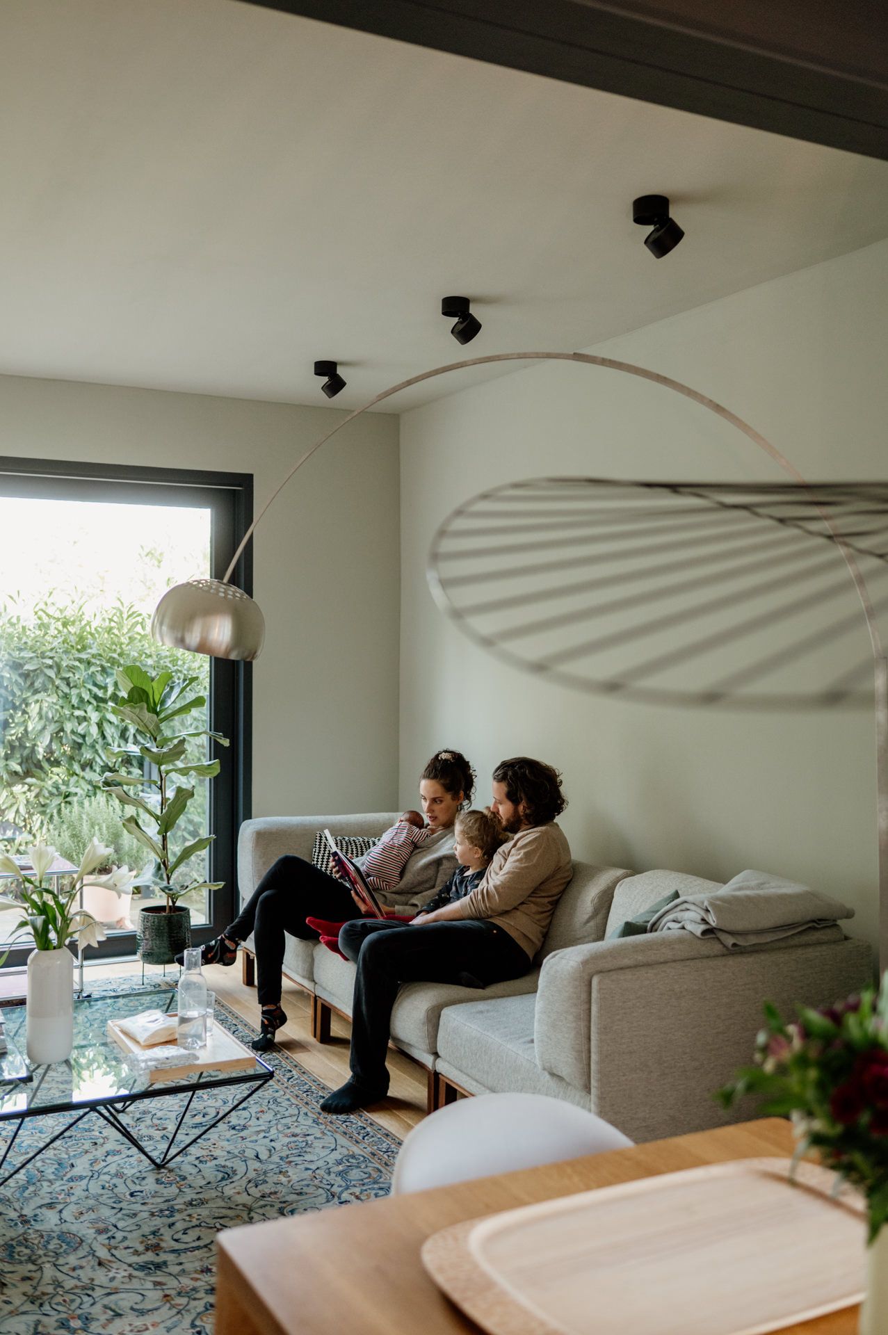 Familie sitzt auf Couch und liest Buch während einer Familiendokumentation