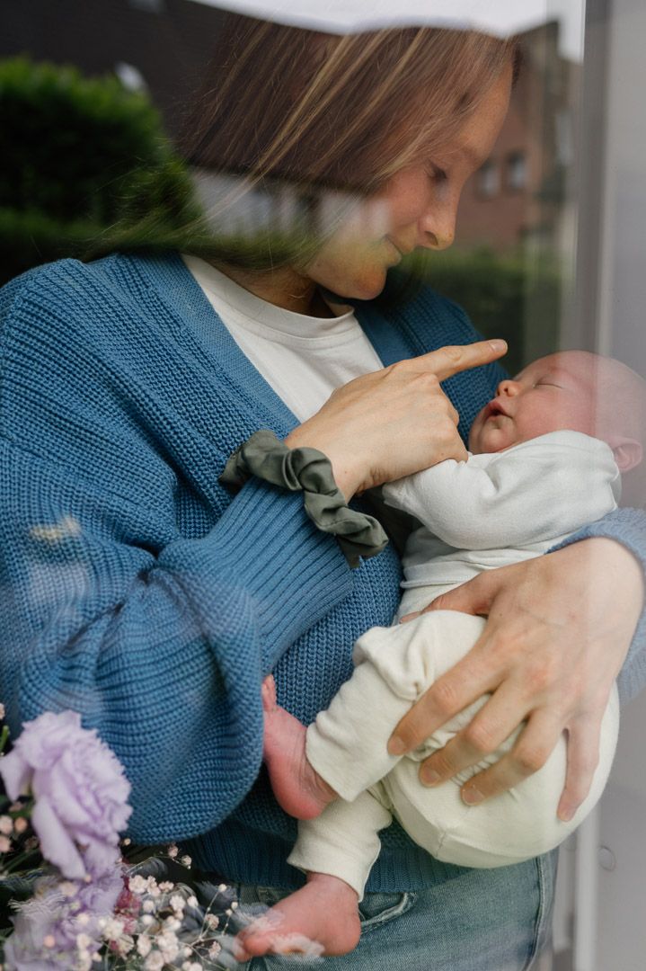 Mama hält und streichelt liebevoll ihr Baby bei einer Homestory