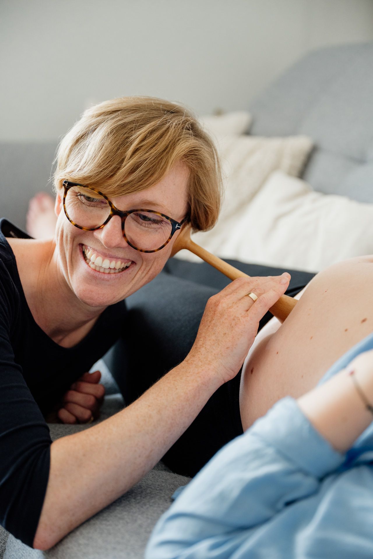 Hebamme horcht am Schwangerschaftsbauch