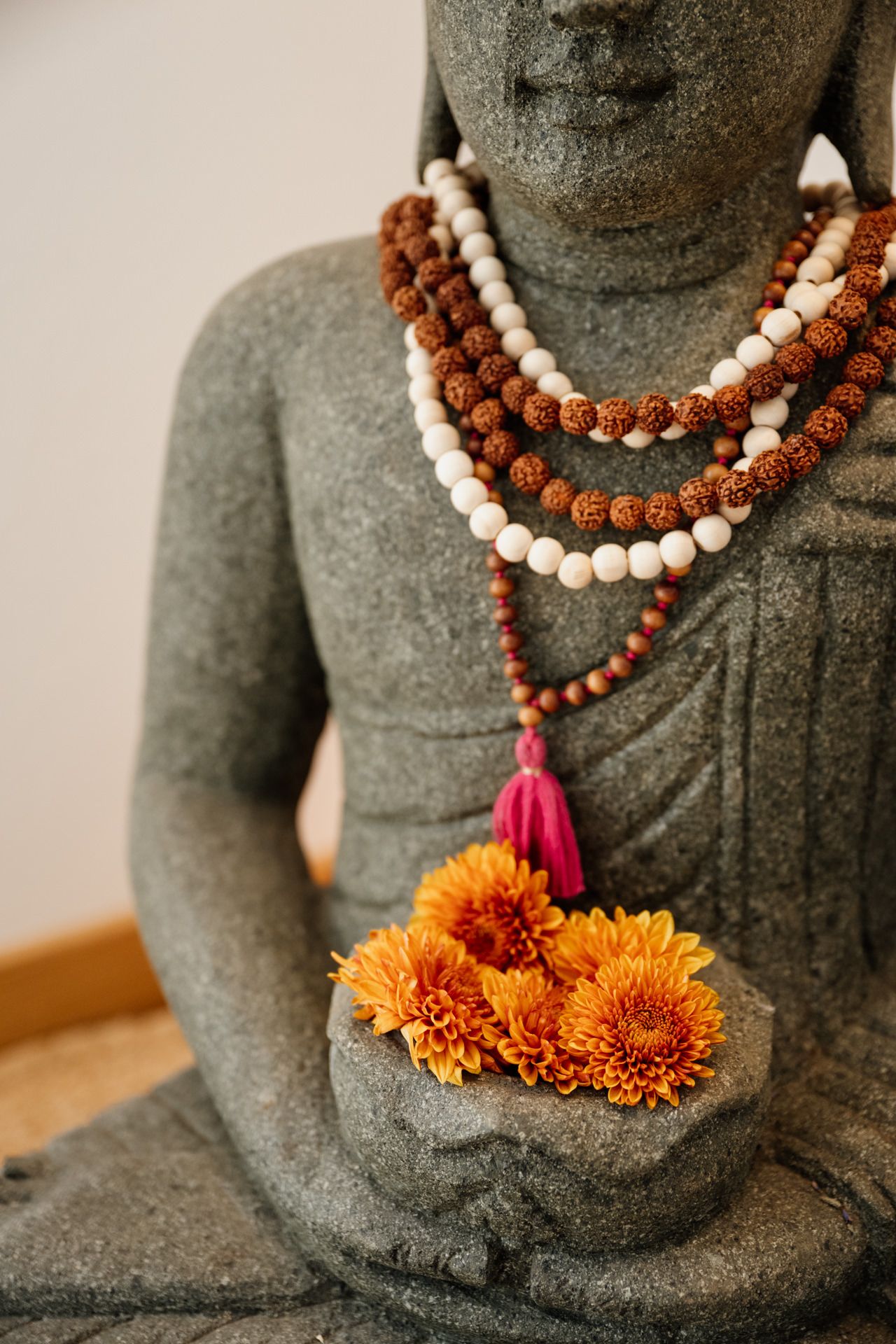 Blumen in den Händen einer Buddhastatue