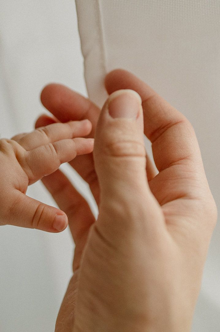 Kleinkindhand berührt Hand einer Erwachsenen