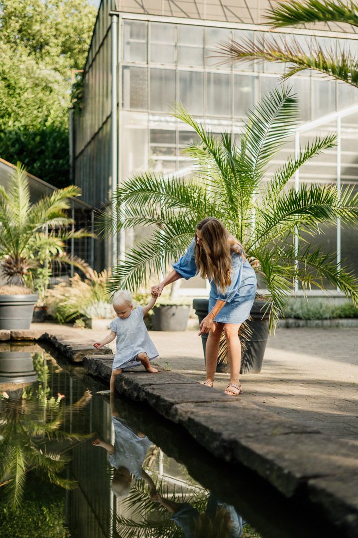Mama und Kind spielen an einem Teich in Duisburg