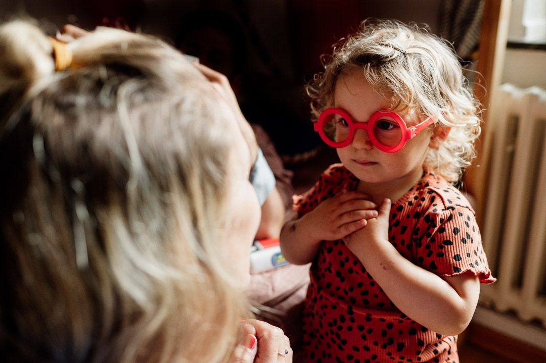Kleinkind mit Spielbrille schaut Mama an