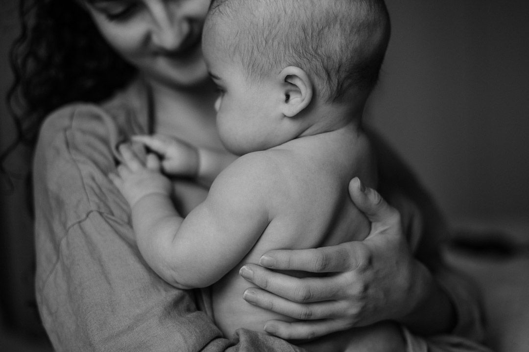 Mutter hält Baby mit Haut auf dem Arm