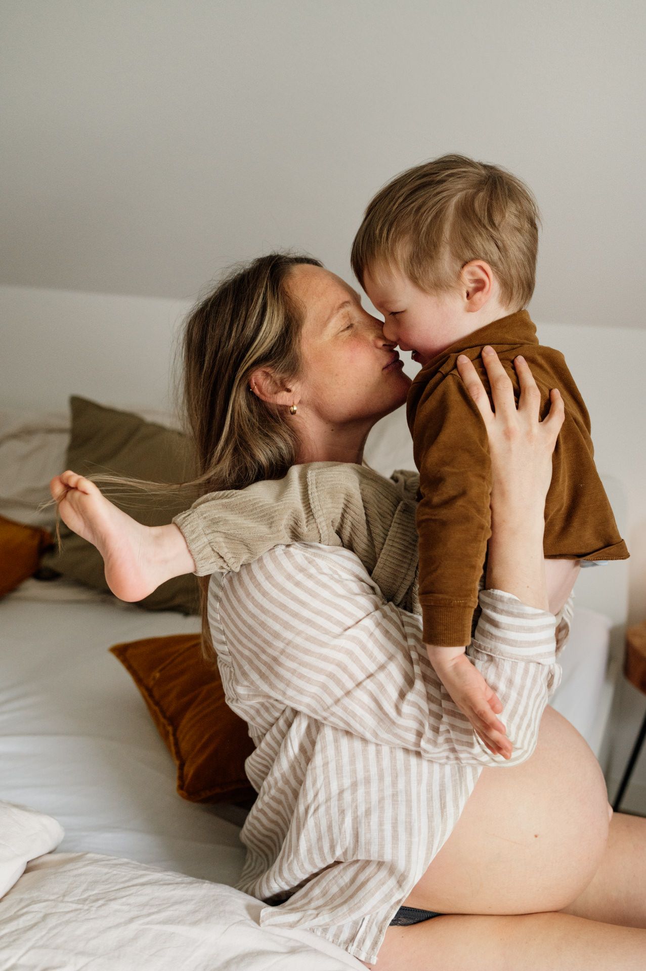 Kleinkind sitzt auf Babybauch seiner Mama