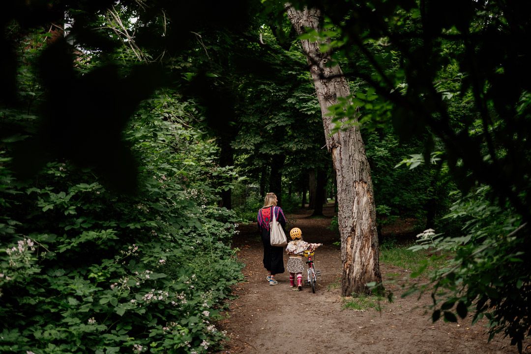 Mutter und Kind auf Fahrrad laufen durch den Wald