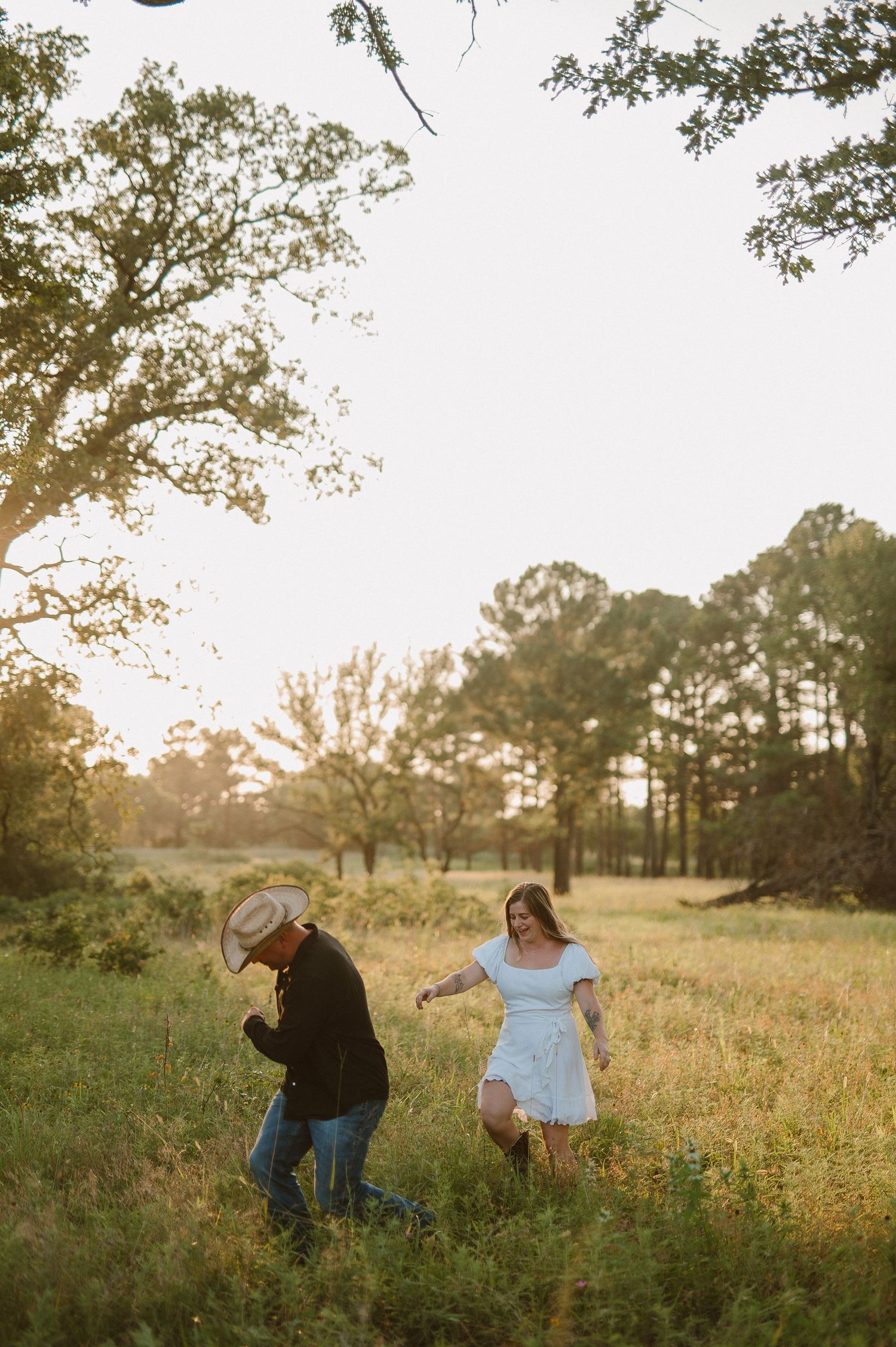 Couple walking through tall grass during an outdoor session in fort worth, tx