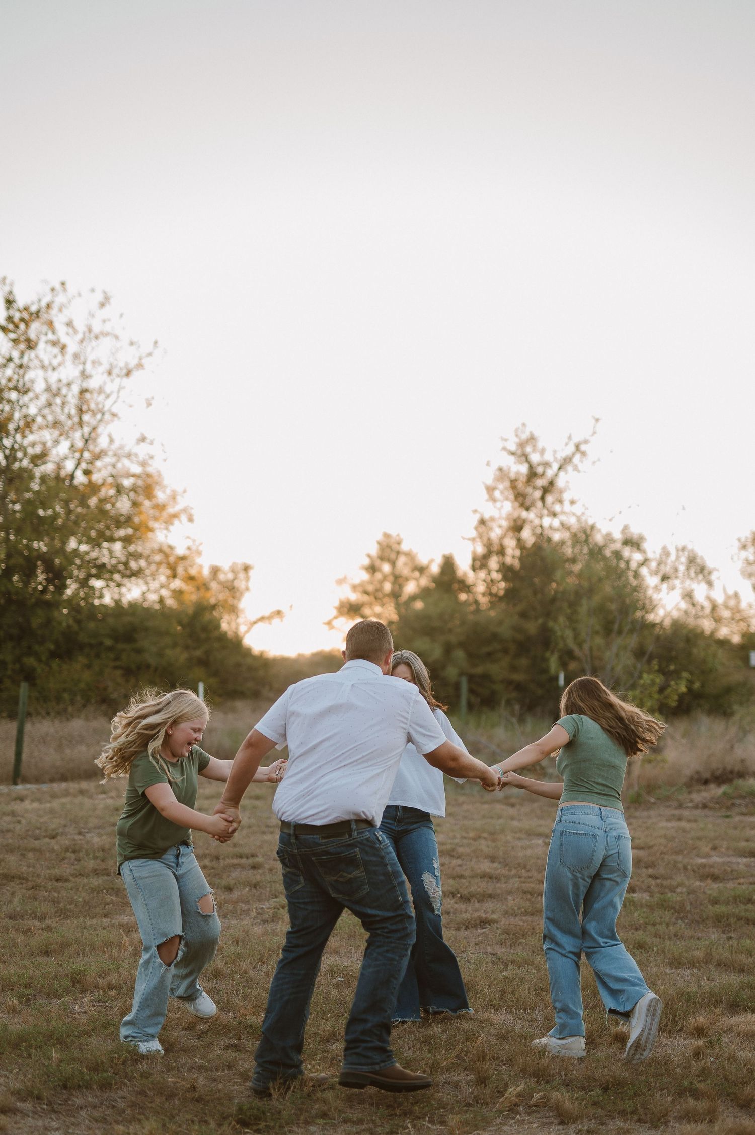Family in a field playing ring around the rosy in Lake Worth, Tx