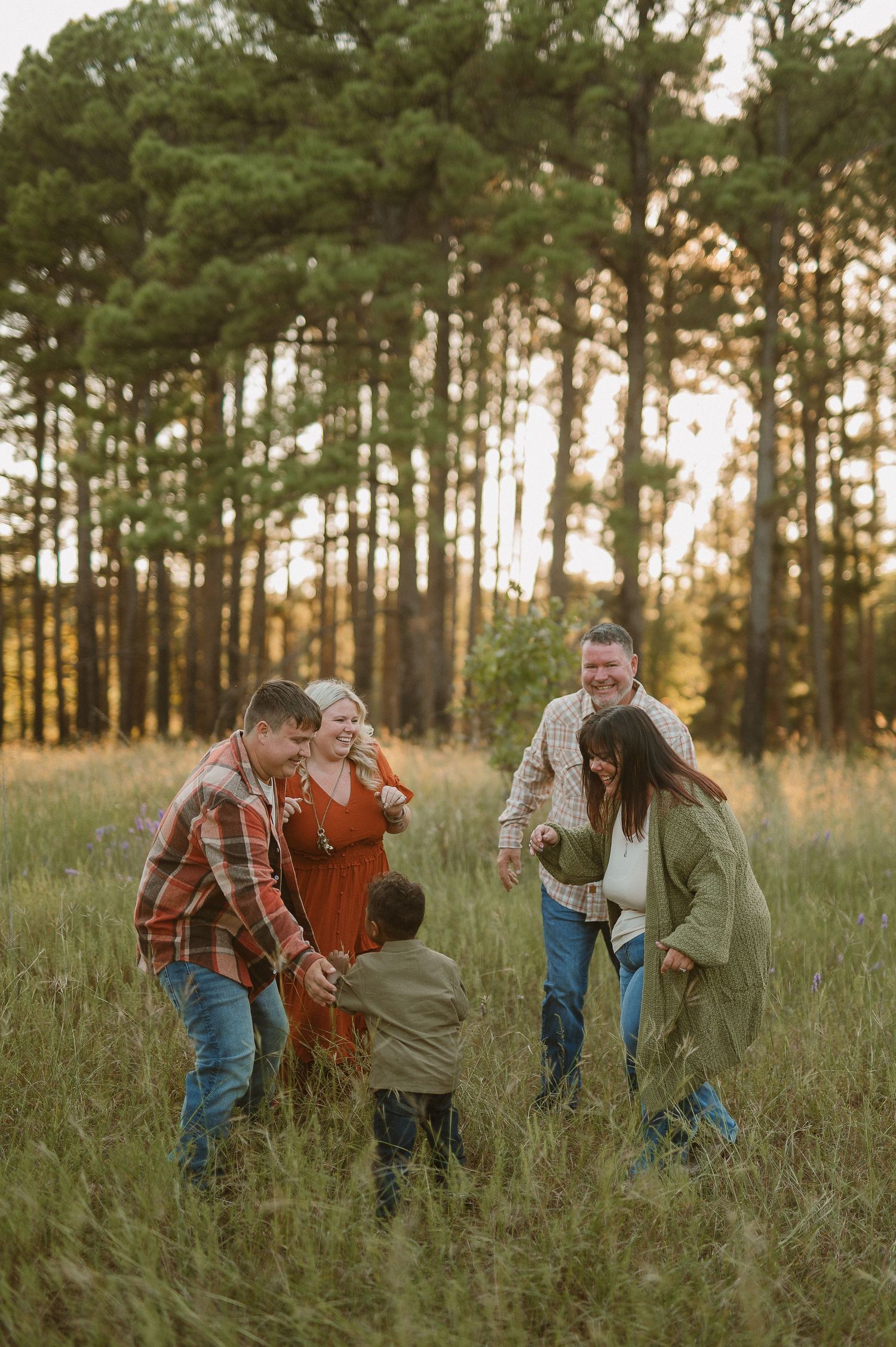 Family playing tag in the tall grass during family session in Fort Worth, Tx