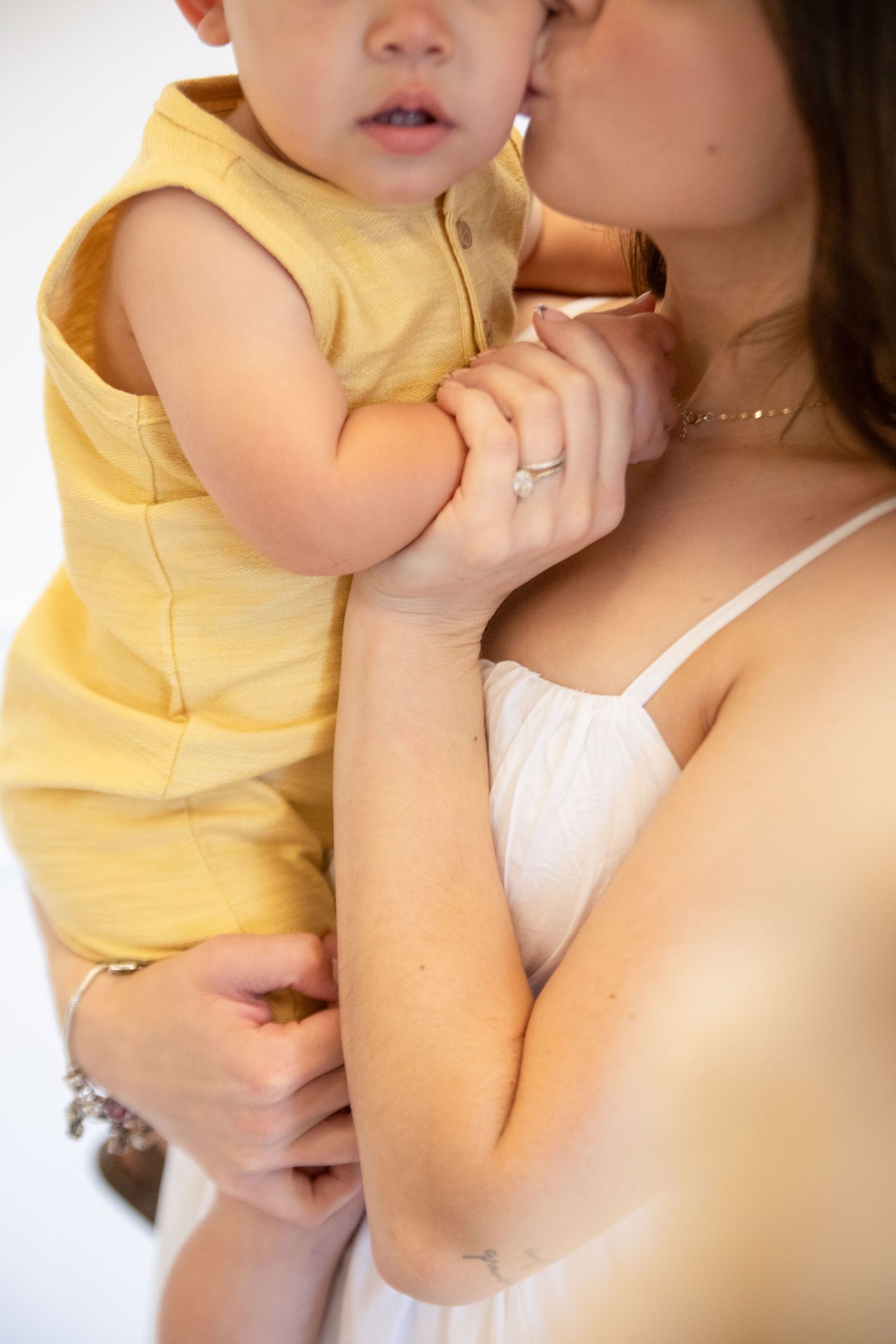 Close up detail picture of a mother with her baby in a soft studio setting, captured in a warm motherhood moment.