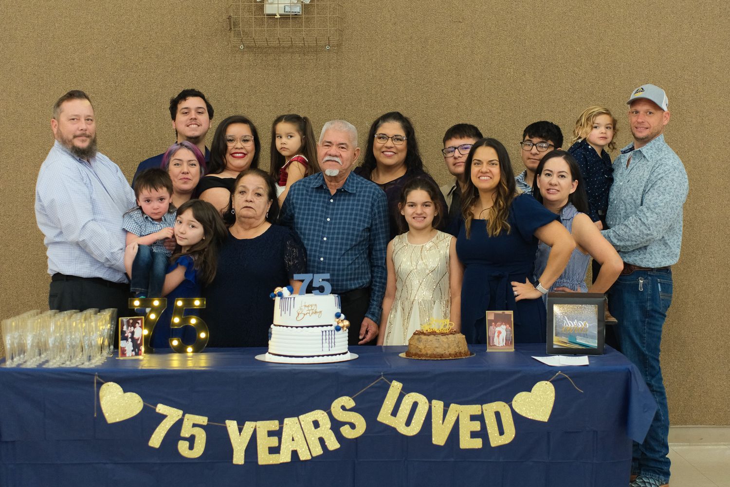 Family gathering around a cake celebrating a 75th birthday milestone with '75 Years Loved' banner.