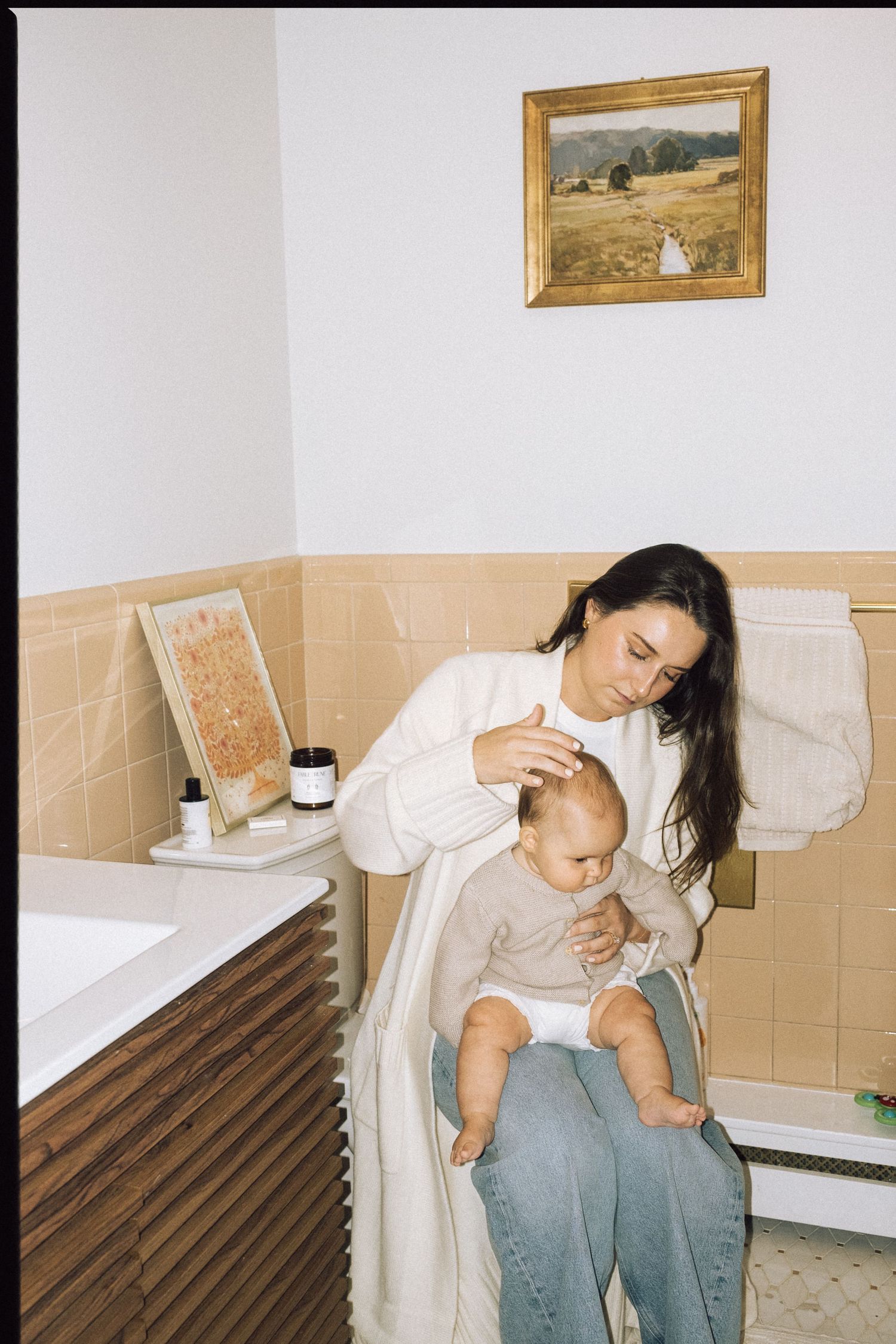 Intimate bathroom scene with parent and child in natural light.