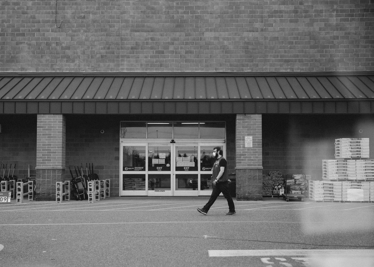 Brick commercial building facade with multiple store entrances shown in monochrome.