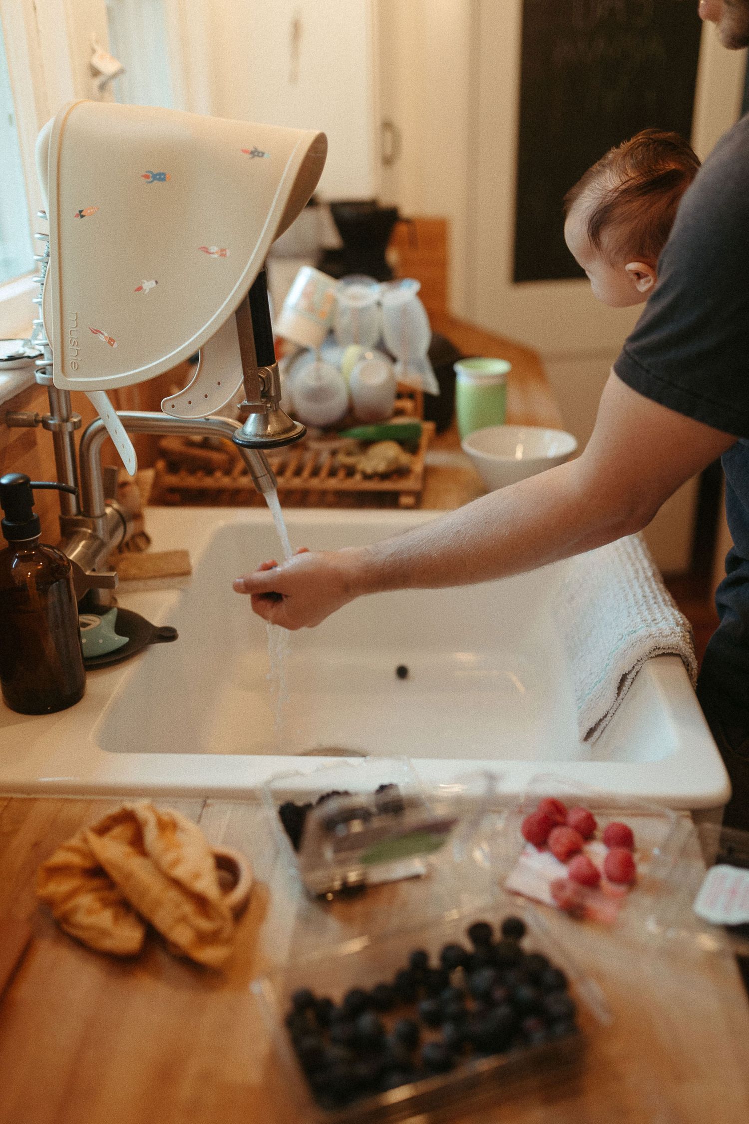 Fresh berries and ingredients laid out on a white kitchen counter for food preparation.