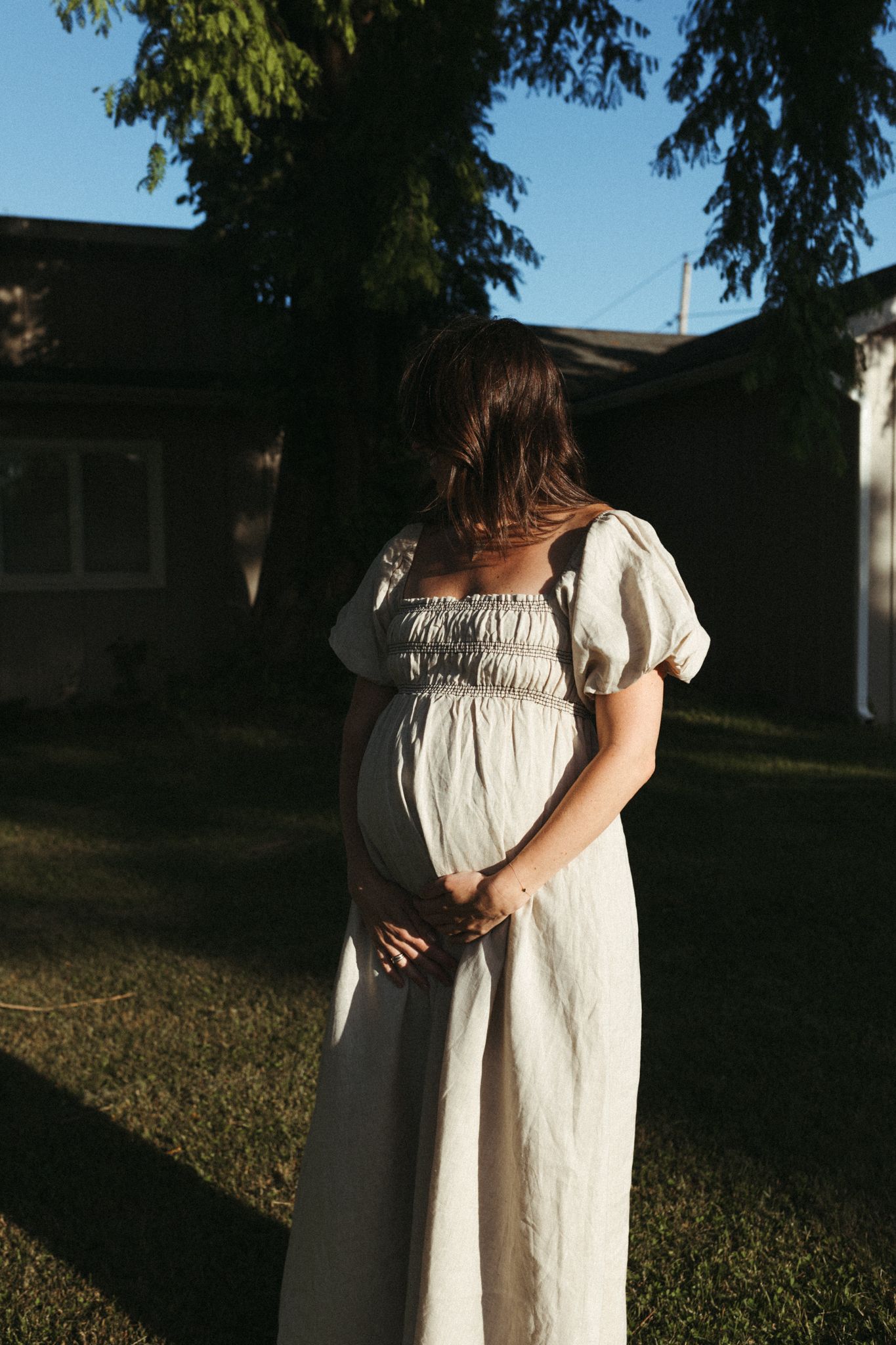 Expecting mother in a flowing dress during her Long Island waterfront maternity session.