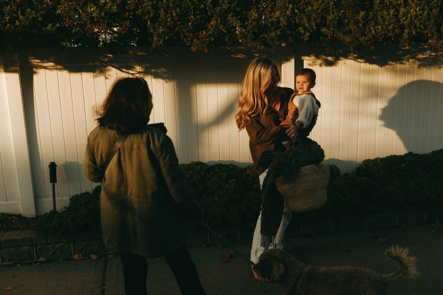 Silhouettes walking along a wooden pathway during golden hour.