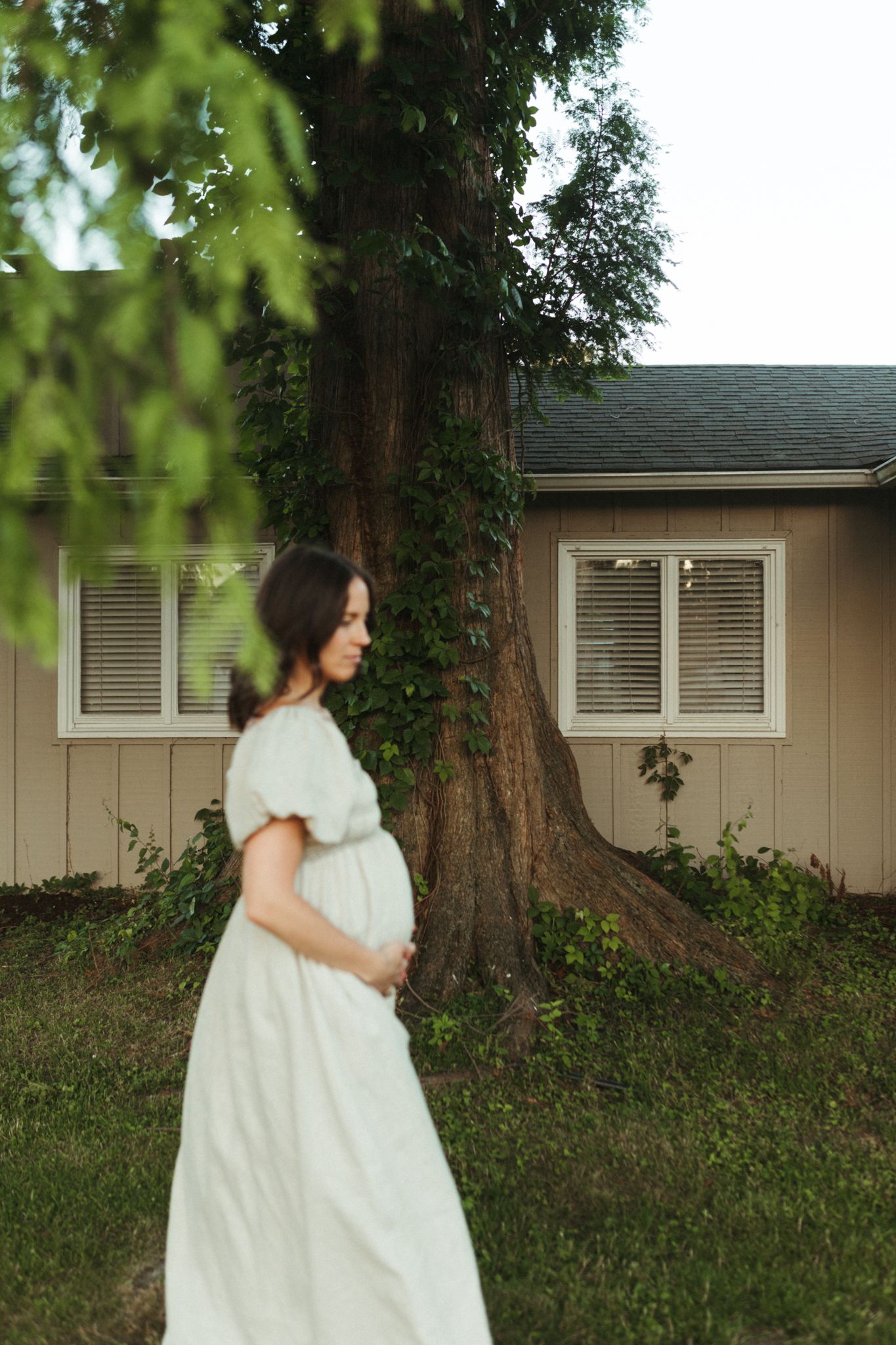 Expecting mother in a flowing dress infront of tree in her front yard of Long Island.