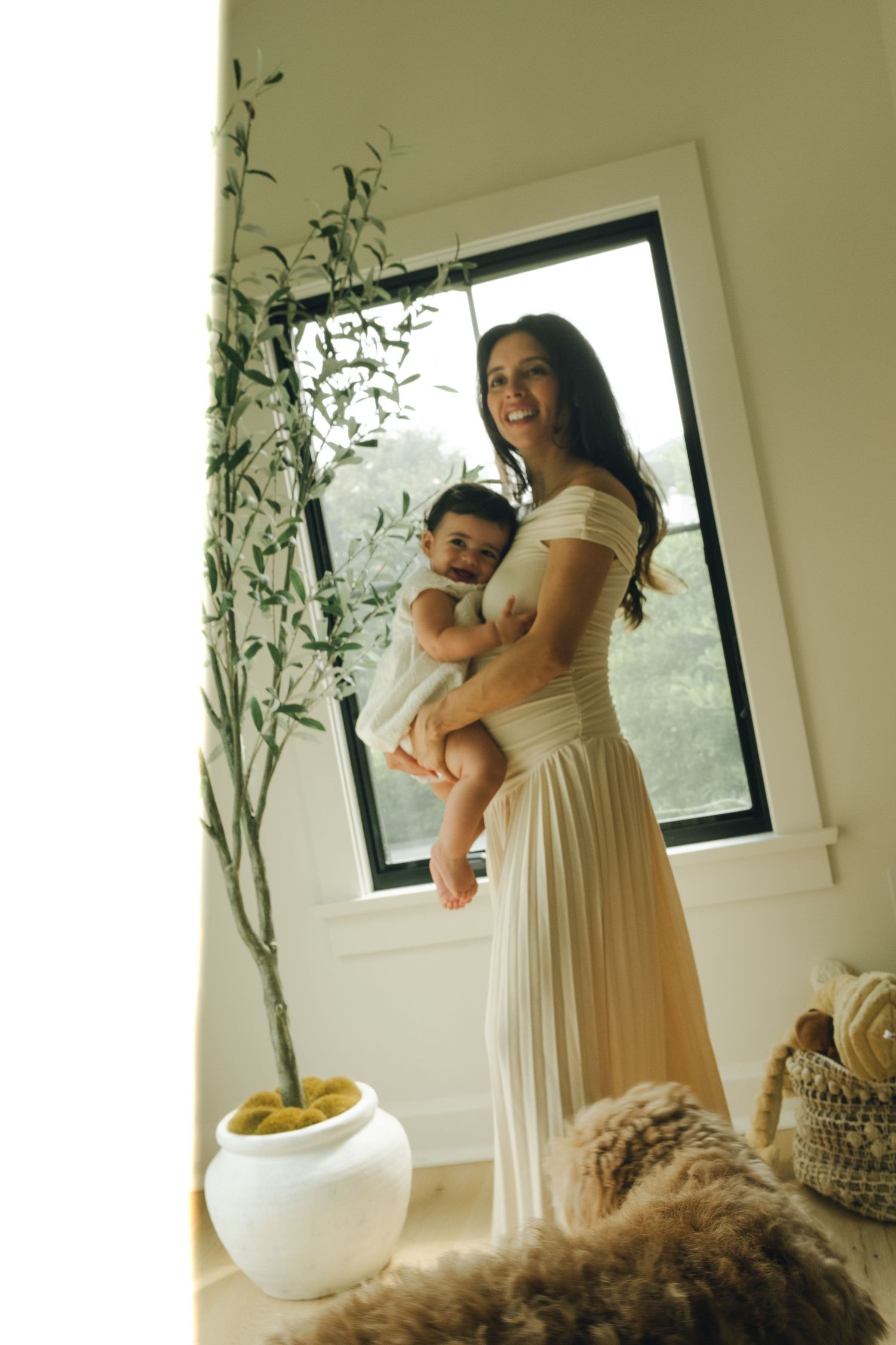 Bright interior room with window light and decorative vines showing tender family moment.
